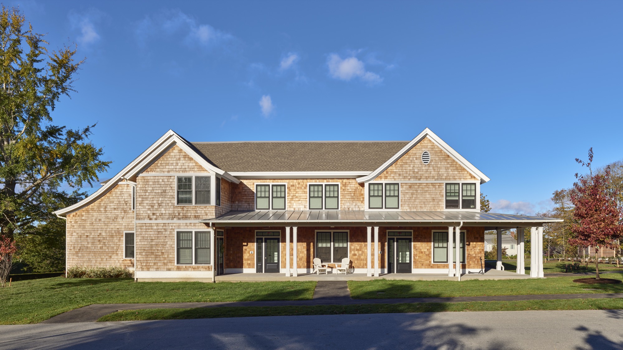 Two-story cedar-shingle building with a covered front porch